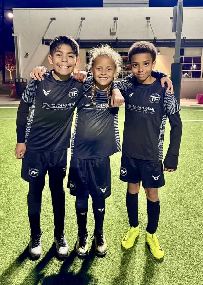 Youth soccer players training with Total Touch Football on an outdoor field